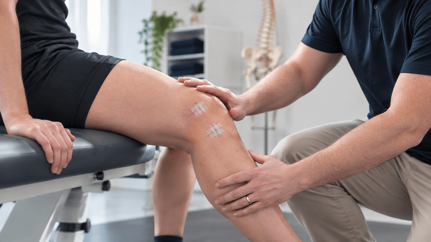 Physiotherapist assessing a patient's knee following surgery